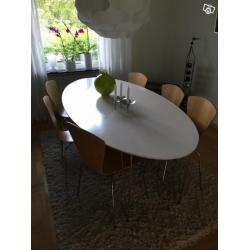Runt kösbord och ovalt matsalsbord med stolar